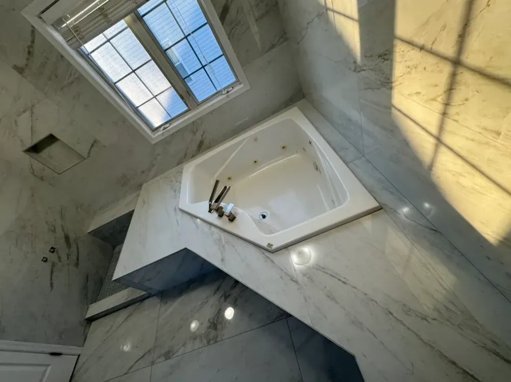 View from above of the corner tub and its marble-look platform