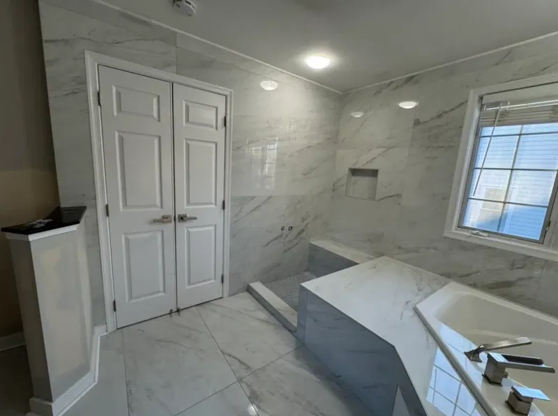 Tiled shower bench, niche and tub platform beside the closet doors