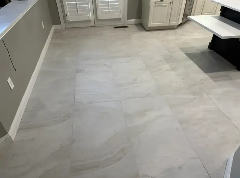 Large rectangular floor tiles running along the kitchen wall to the window